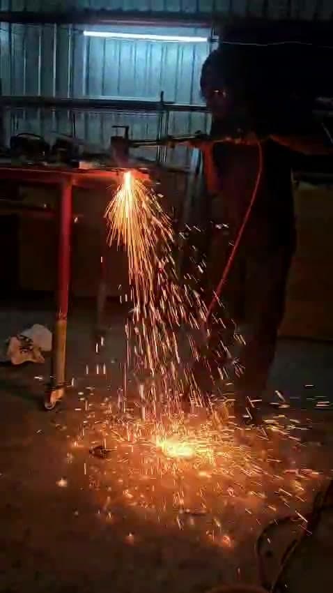 Kris cutting steel with a torch in the shop, sparks pouring onto the floor